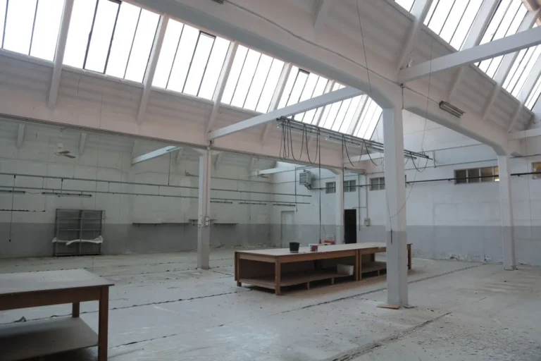 Spacious empty industrial unit with skylights and concrete floor
