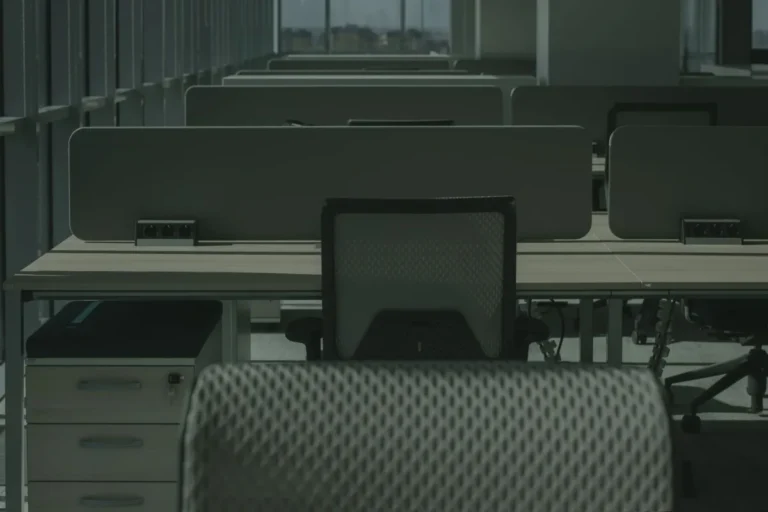 Orderly rows of office desks and chairs in an empty workspace