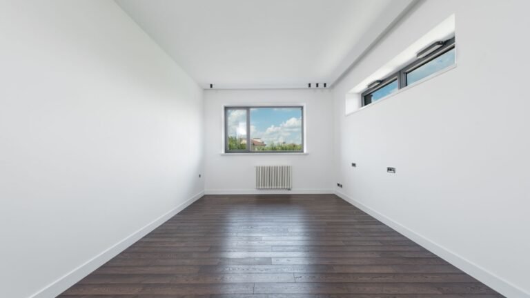 Empty room with white walls and parquet flooring